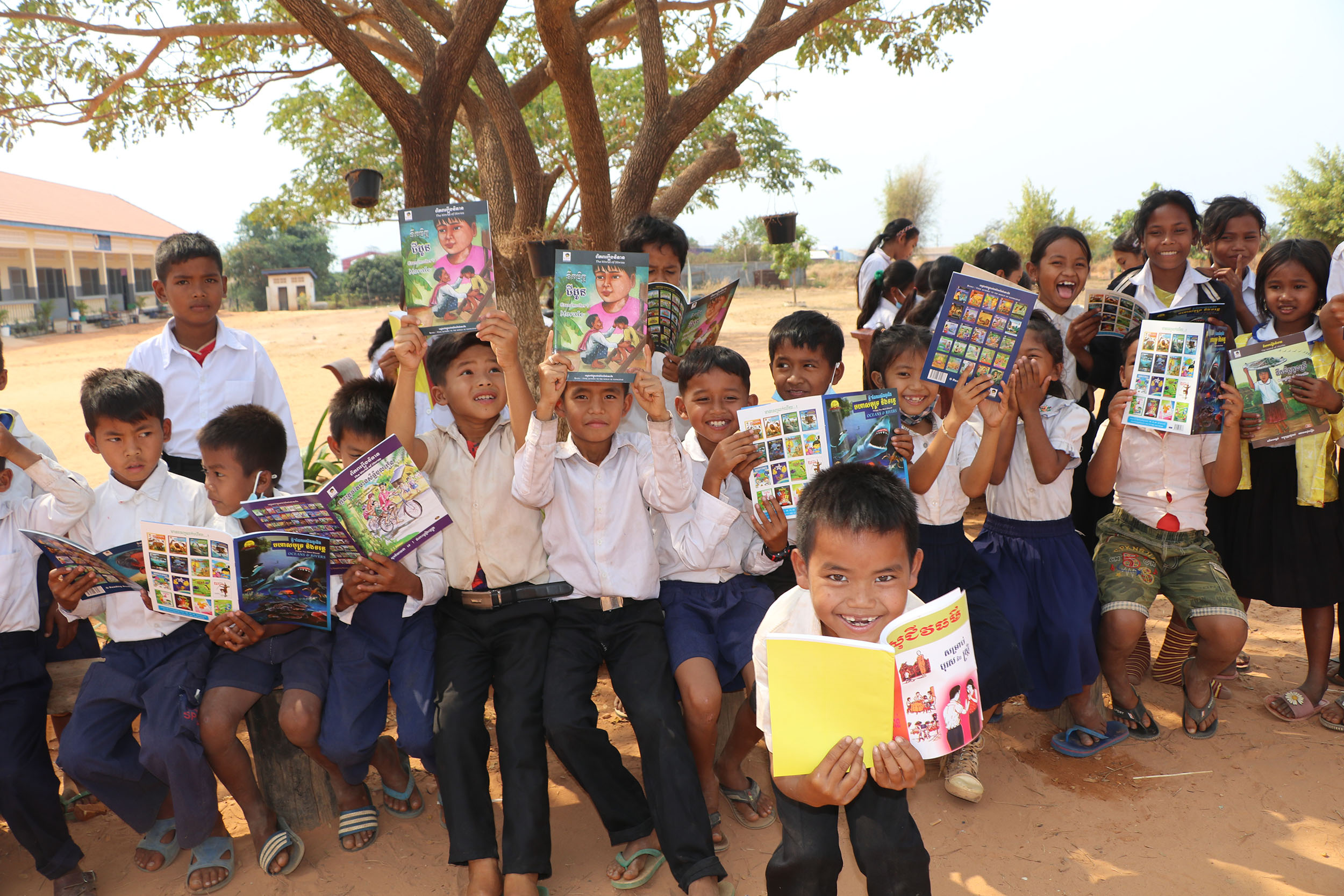 寄贈された本を手に読書する子どもたち